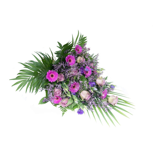 En bårebuket i lilla nuancer med roser og nellike